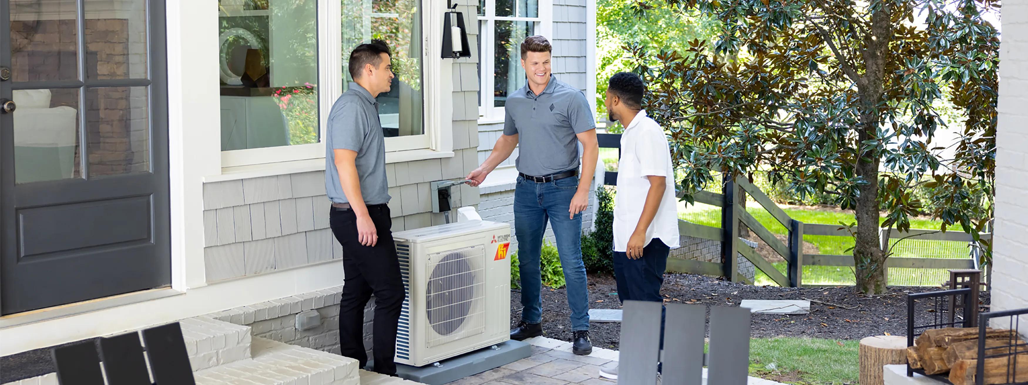 Contractors demonstrating recently installed heat pump to homeowner