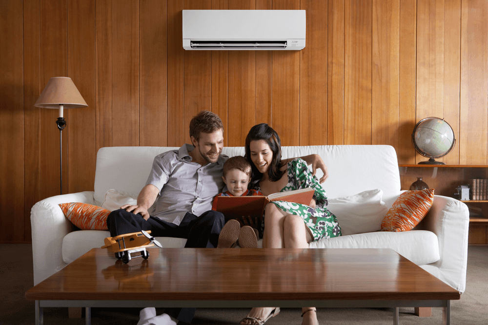 family sitting on a couch with a GX model wall unit