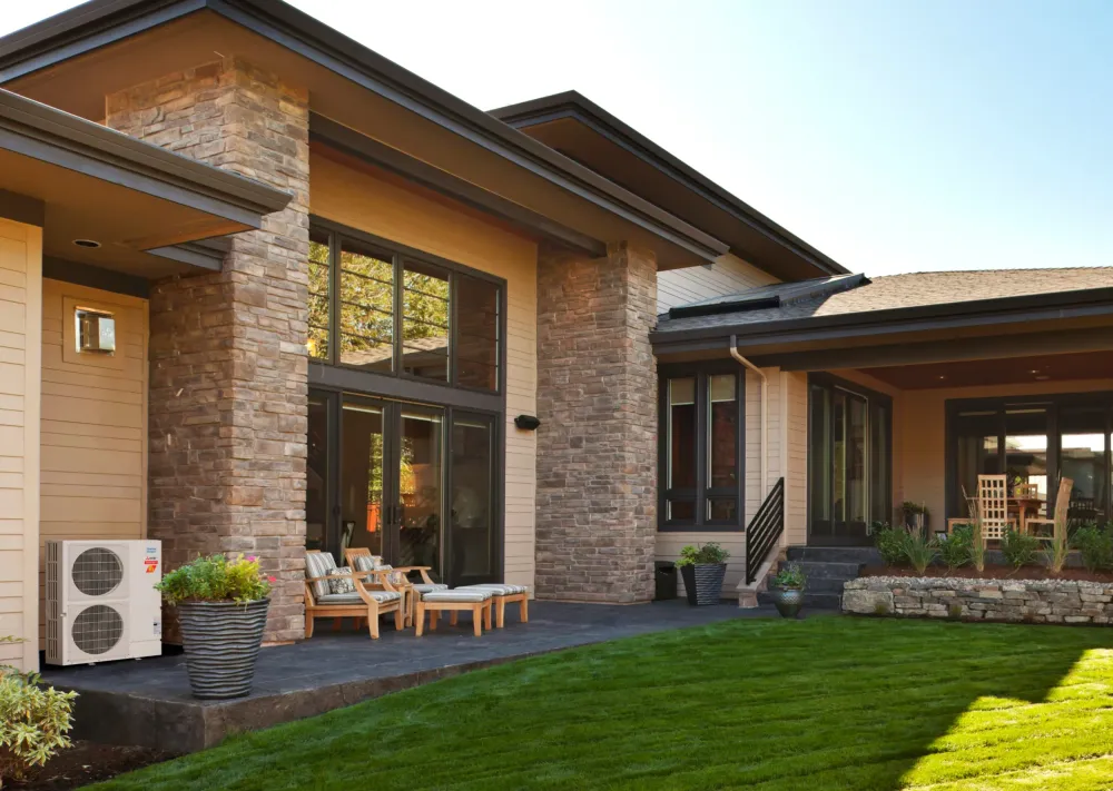 clean modern home from backyard with mitsubishi electric mini split heat pump unit