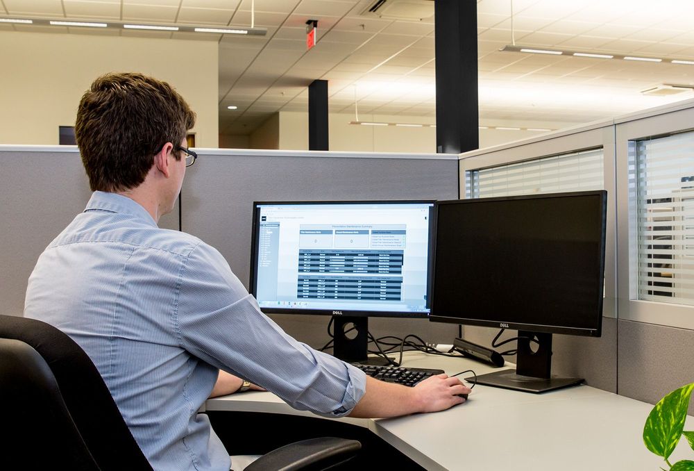 Cubicle worker managing City Multi controls on computer