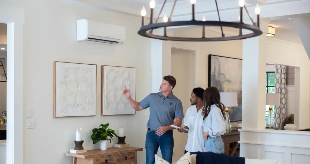 interior of home with modern living room with mitsubishi electric heat pump mini split wall unit and diamond contractor assisting homeowners