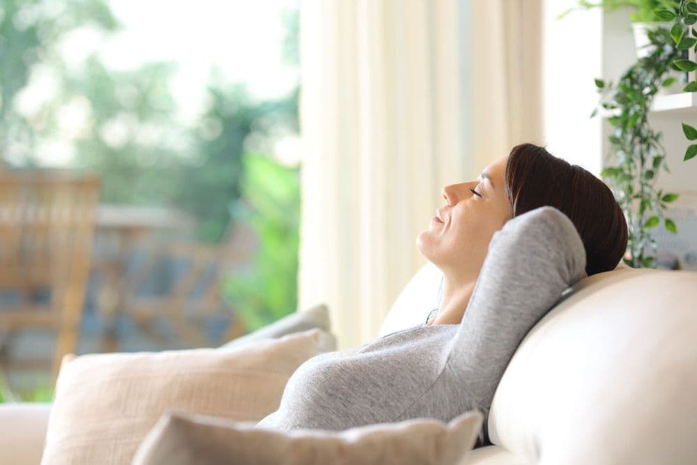 Woman relaxing on a couch in a bright living room