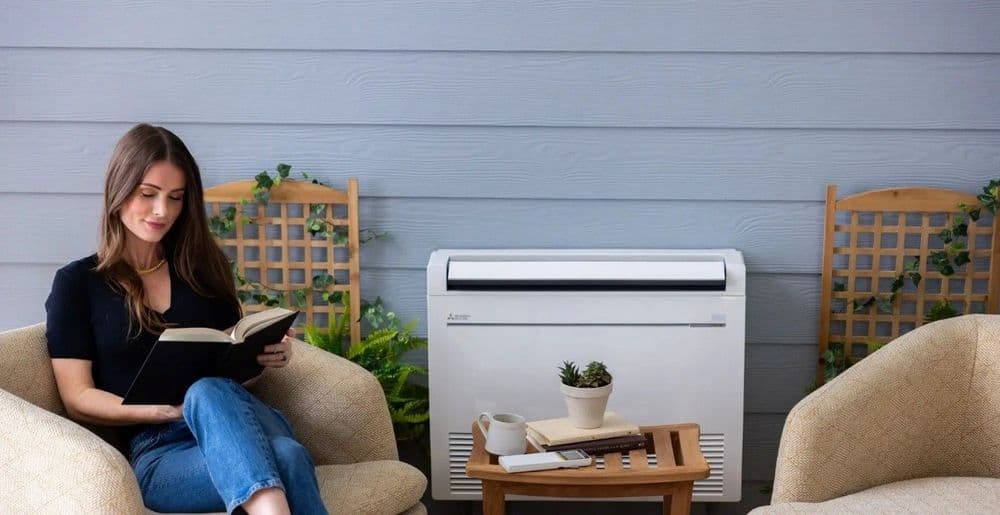Woman reading next to a quiet outdoor unit